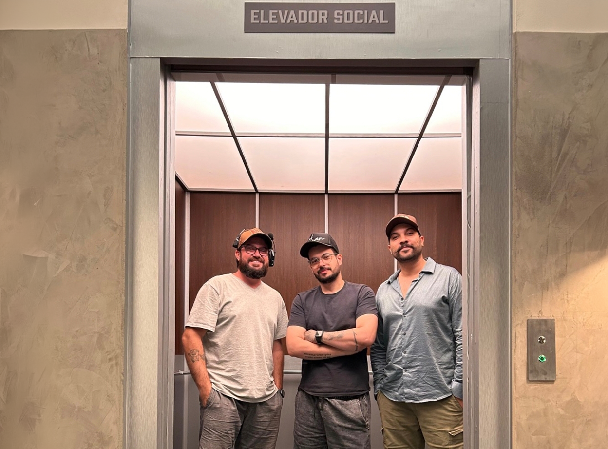 Equipe de produção reunida em frente a um elevador